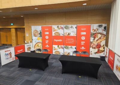 Kiosque d’exposant Saputo avec panneaux imprimés et mobilier