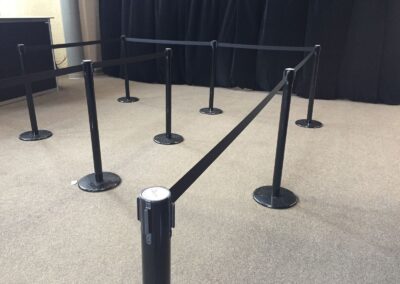 Poteaux avec cordons rétractables pour organiser une file d’attente