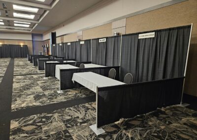 Rangée de kiosques avec rideaux noirs, tables et espaces individuels