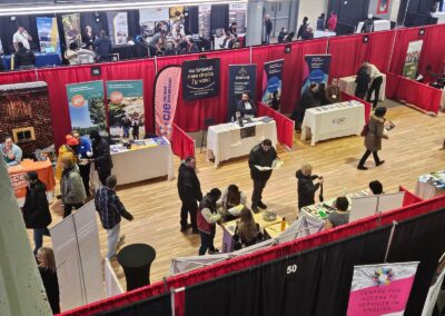 Salon d’exposition aménagé avec kiosques et séparateurs de rideaux rouges et noirs